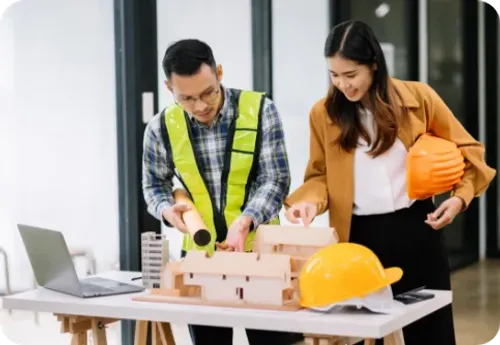 Construction professionals collaborating on architectural models and project planning